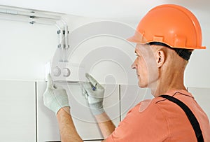 Worker is connecting the humidity sensor of the ventilation system
