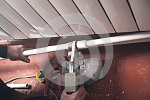 Worker connecting plastic pipe. Installing water heating radiator