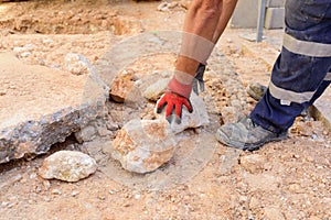 Worker on a construction site cleaning the area of rubble and garbage