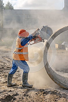 Worker at the construction site cuts the ring