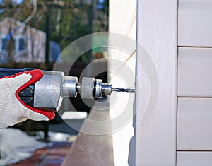 Worker at construction site drills wall drilling machine