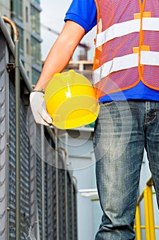 Worker on construction site with helmet or hard hat