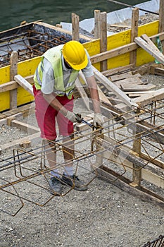 Worker at the construction site making reinforcement metal