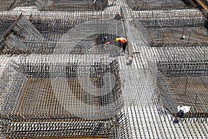 Worker in the construction site making reinforcement metal framework for concrete pouring