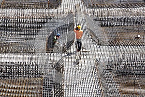 Worker in the construction site making reinforcement metal framework for concrete pouring