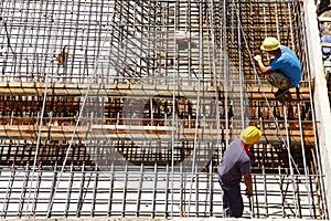 Worker in the construction site making reinforcement metal framework for concrete pouring