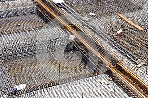 Worker in the construction site making reinforcement metal framework for concrete pouring