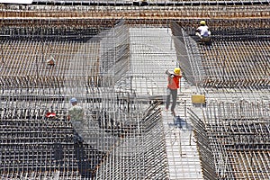 Worker in the construction site making reinforcement metal framework for concrete pouring