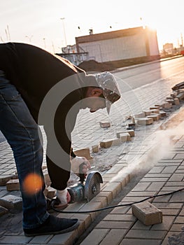 Worker at the construction site saws building materials