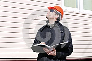 Worker on a construction site in winter looks at the drawing