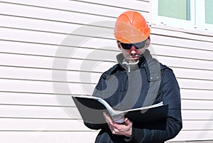 Worker on a construction site in winter looks at the drawing