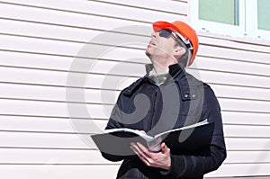 Worker on a construction site in winter looks at the drawing