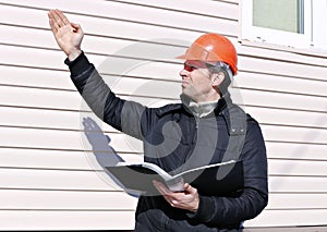 Worker on a construction site in winter looks at the drawing