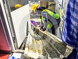 Worker or contractor hauling raw cement by metal sheet for foundation ,construction concept