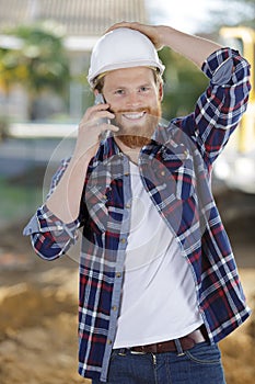 worker contractor man wearing hardhat talking on mobile phone