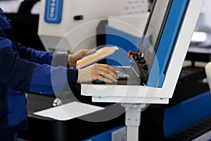 Worker at control console of laser cutting machine