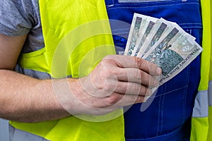 Worker counting his earnings, Polish money, Concept of wages and labor costs in industry