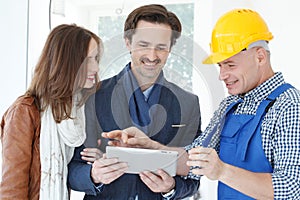 Worker and couple at construction site