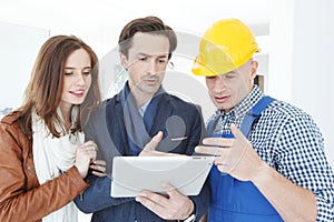 Worker and couple using tablet