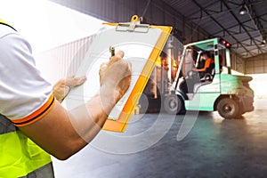 Worker Courier Holding Clipboard his Control Loading Package Boxes into Cargo Container. Supply Chain. Trucks Loading at Dock.