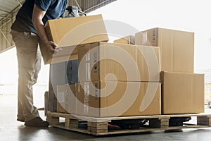 Worker courier lifting shipments boxes at the warehouse. photo