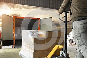 Worker courier unloading cargo pallet shipment goods into a truck