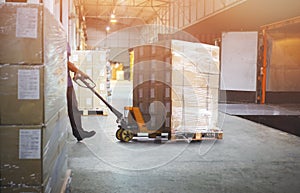 Worker Courier Unloading Package Box Out Of Cargo Container. Delivery service. Truck Loading at Dock Warehouse. Supply Chain