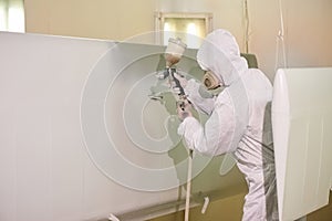 Worker in coverall using airbrush.