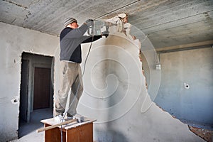 Worker crashing inner septum using jackhammer in flat.