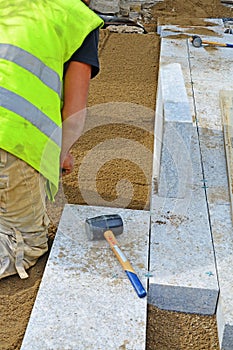 Worker creating screeding sand bedding