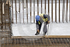 Worker with crowbar removing wooden formworks photo