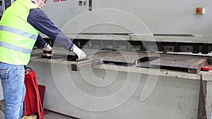 Worker cut metal plate on big machine