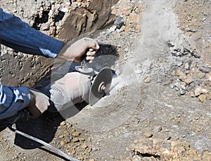 worker cut road by grinder