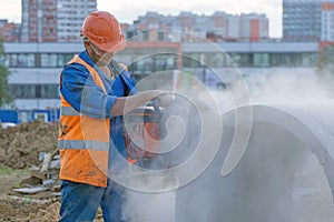 Worker cuts the concrete ring at the construction site