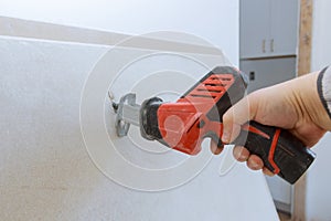Worker cuts with a dirty saw drywall cutting gypsum board
