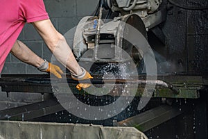 A worker cuts granite. The cutter cuts granite. Stone processing machine