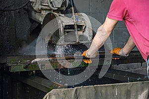 A worker cuts granite. The cutter cuts granite. Stone processing machine