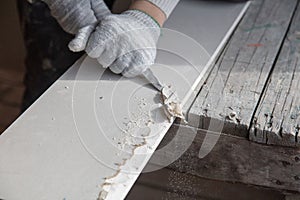 Worker cuts with a knife drywall repair