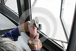 worker cuts a metal pipe with some electric device or appliance