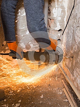 Worker cuts a metal pipe with sparks