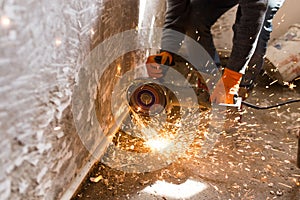 Worker cuts a metal pipe with sparks