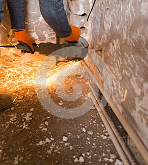 Worker cuts a metal pipe with sparks