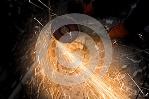 Worker cuts a metal pipe with sparks