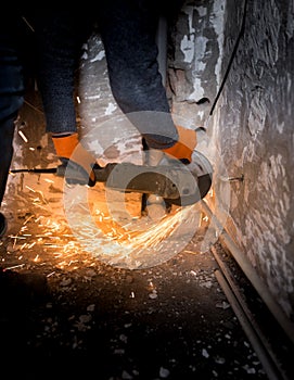 Worker cuts a metal pipe with sparks