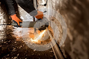 Worker cuts a metal pipe with sparks