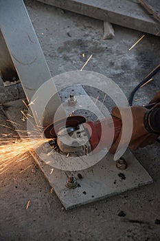 Worker cuts a metal with some electric device or appliance