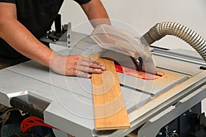 Worker cuts the parquet manually on a circular saw