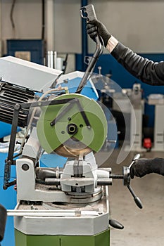 Worker cuts a piece of material with a circular saw machine. Industrial engineer working on cutting a metal and steel