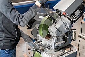 Worker cuts a piece of material with a circular saw machine. Industrial engineer working on cutting a metal and steel