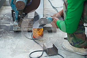 Worker cutting aluzinc metal sheet at building site construction